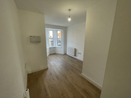 Empty room with wooden floor and white walls.