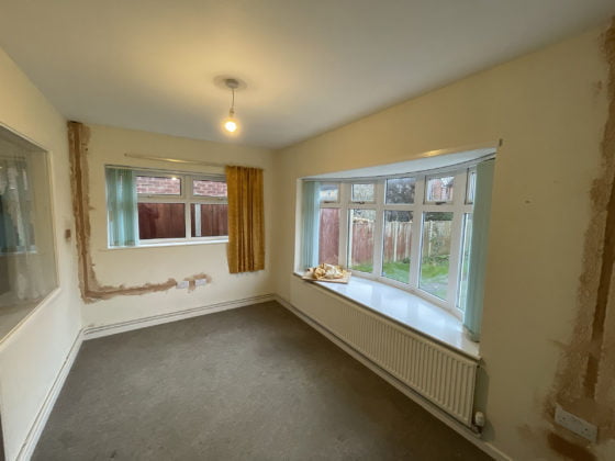 Empty room under renovation with large window.