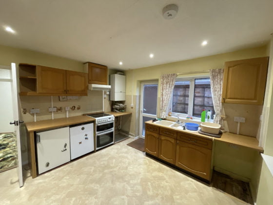 Spacious kitchen interior with wooden cabinets and appliances.
