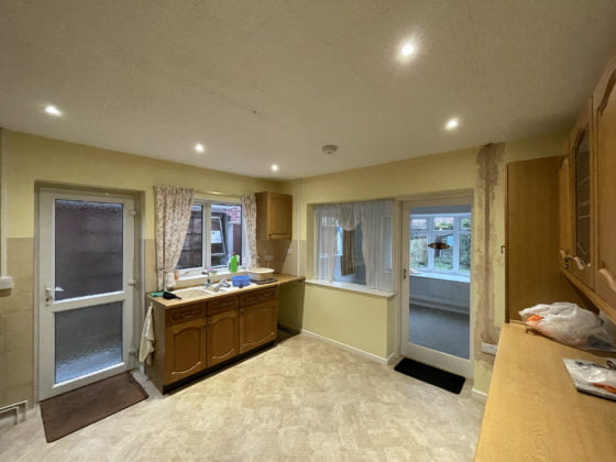 Spacious kitchen interior with wooden cabinets and ample lighting.