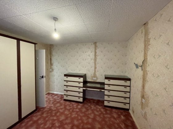Renovation needed: empty vintage room with wallpaper.