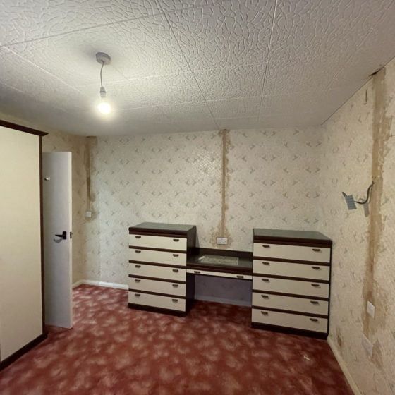 Renovation needed: empty vintage room with wallpaper.