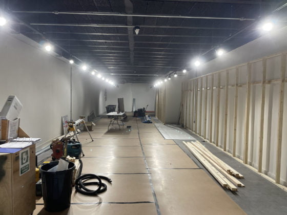 Interior construction site with wooden framing and tools.