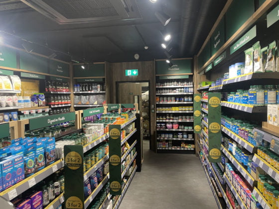 Health supplements aisle in modern pharmacy store.
