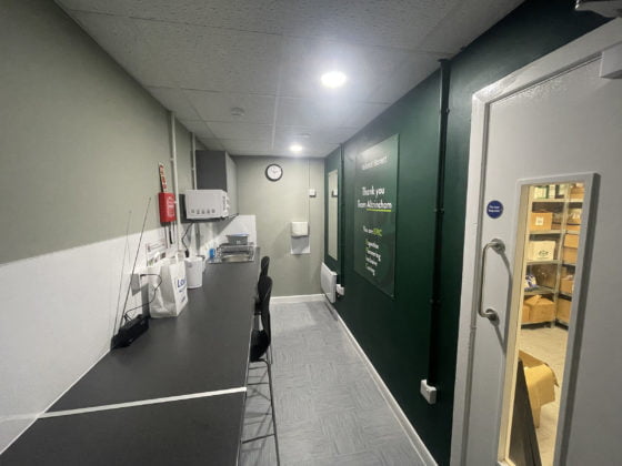 Office corridor with signage and workstations.