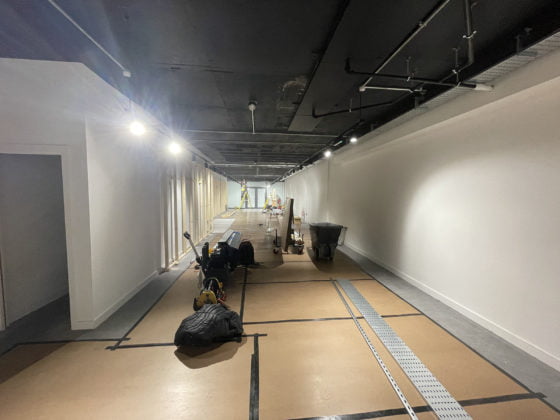 Indoor construction corridor with lighting and tools.