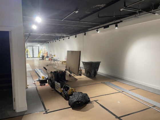 Interior construction site with tools and lighting setup.