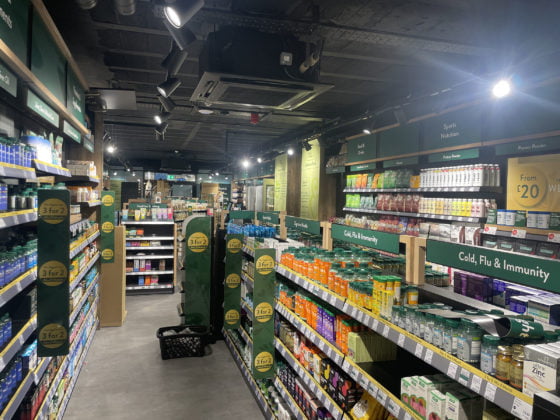 Well-stocked pharmacy shelves with health supplements and offers.