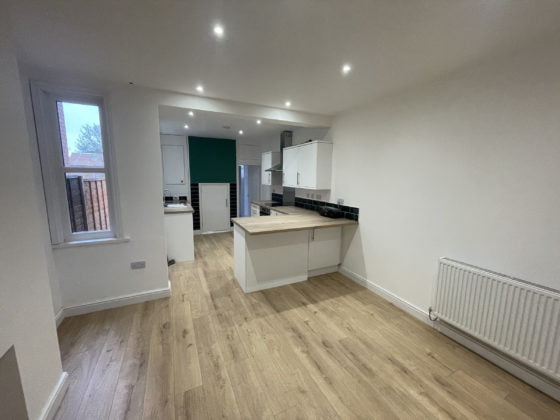 Modern empty kitchen interior with wooden floors.