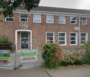 Brick building with number 99 and safety signs.