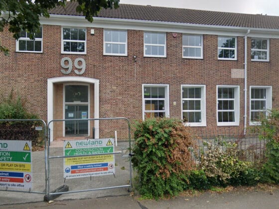 Brick building with number 99 and safety signs.